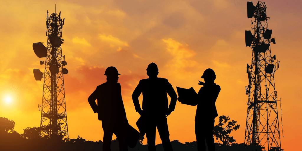 linemen looking at utility towers during sunset