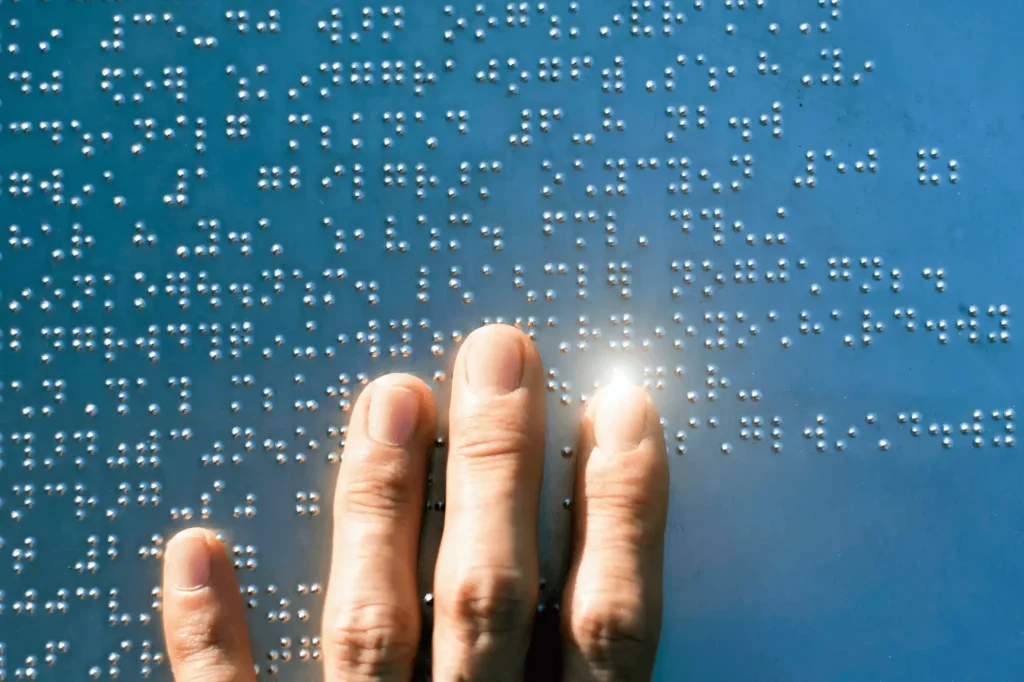 Person using braille to read digital content.