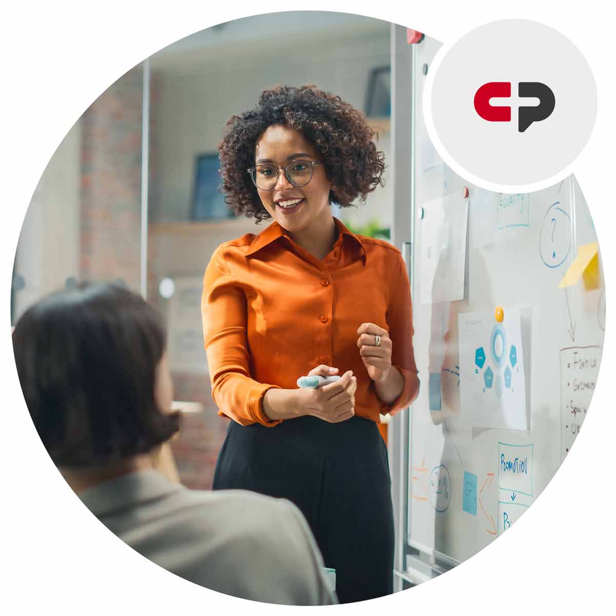 Woman talking in front of a white board holding a marker