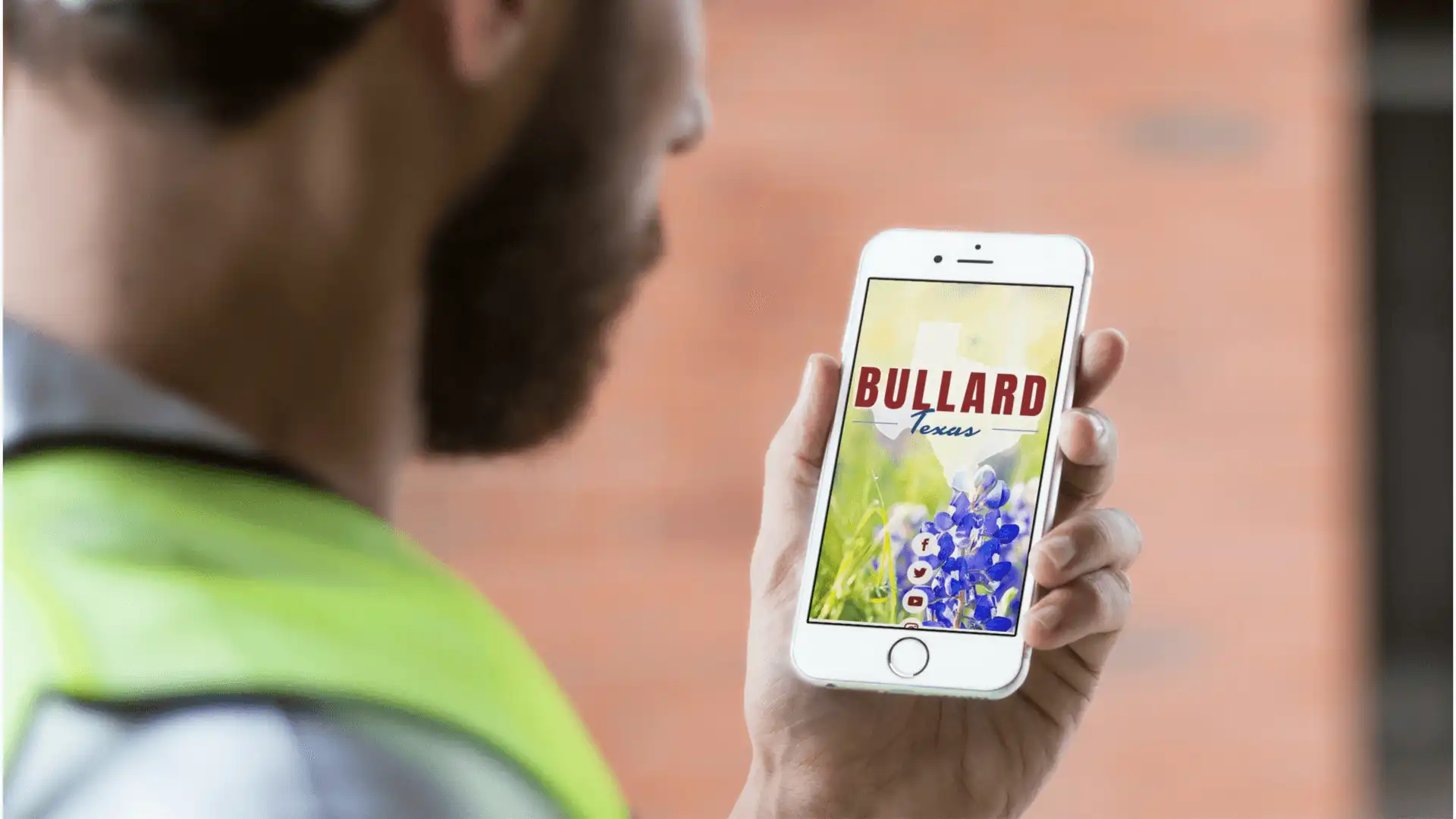 Public Works worker looks at a mobile phone displaying the Bullard, Texas, homepage