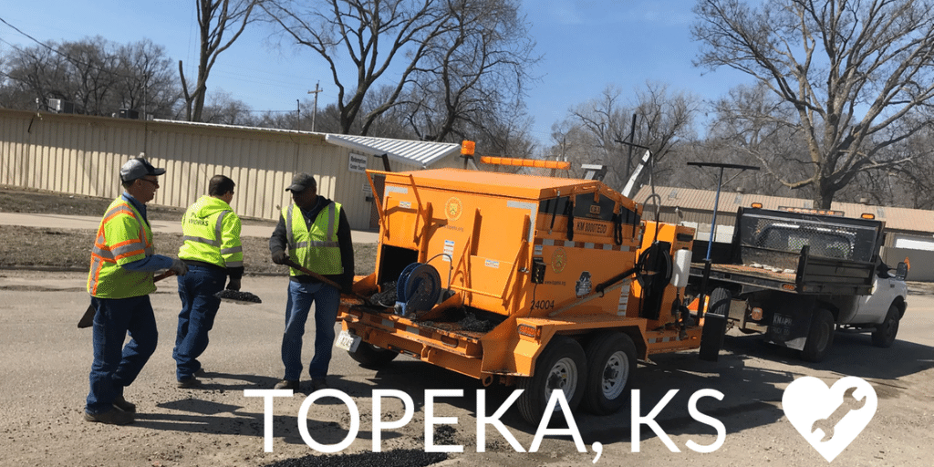 Three security men talking around a tow truck