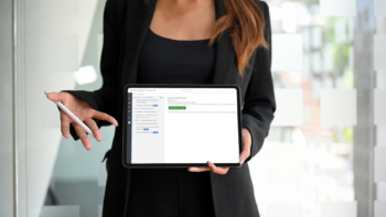 Woman holding up an iPad and pencil