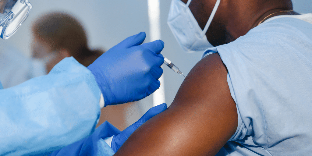 Man in a hospital receiving a vaccine through injection