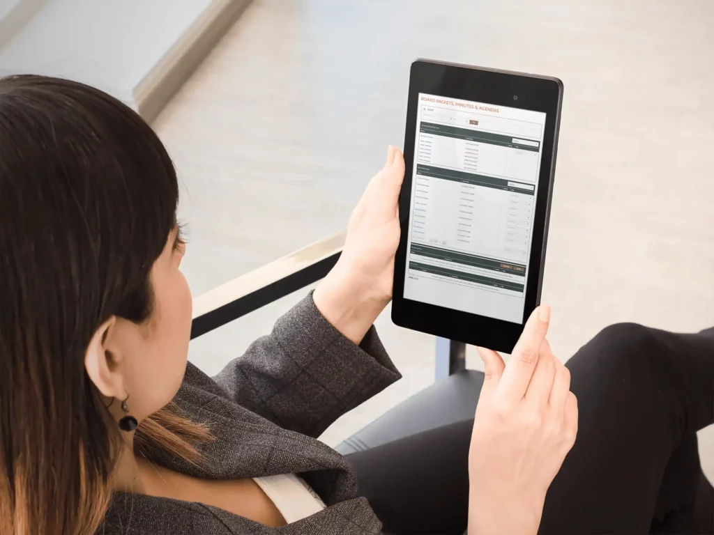 Woman reads a tablet showing agendas of Elbert County, Colorado