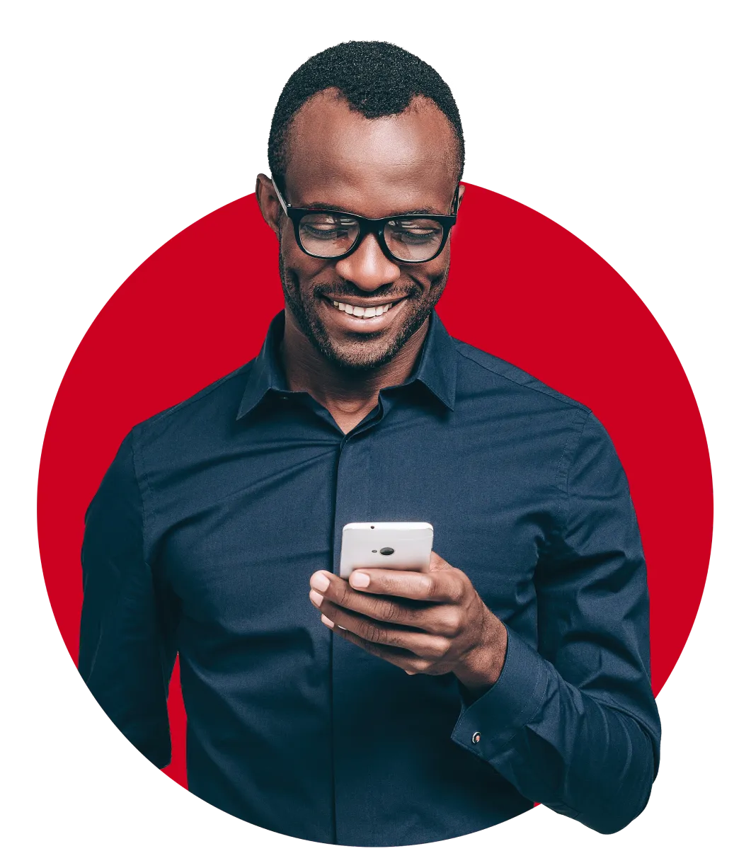 Man wearing glasses smiling down at his phone