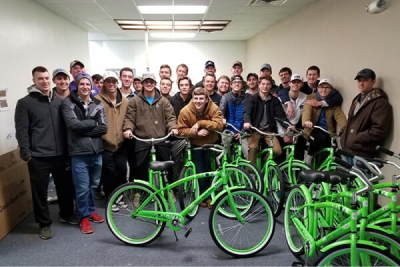 A group of people standing in a room with bicycles