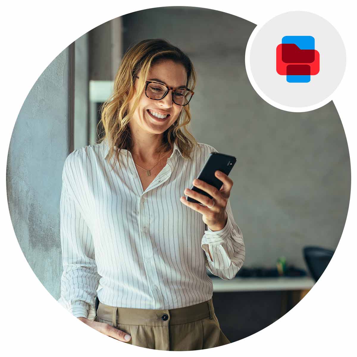 Woman standing at an office looking at her phone