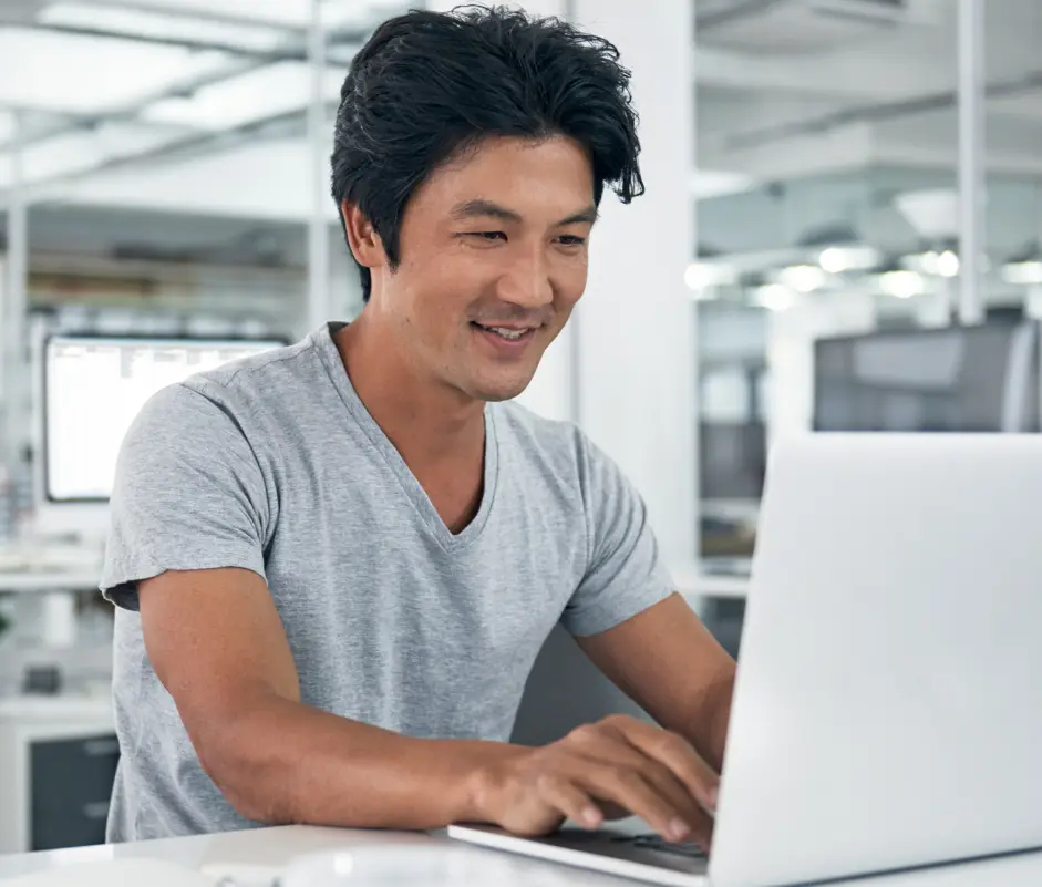 A guy working on laptop, smiling