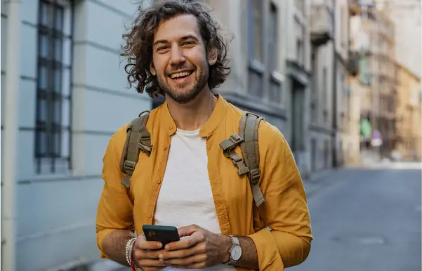 A man smiling while holding smart phone