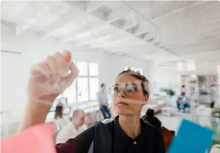 Woman writing notes on a glass wall