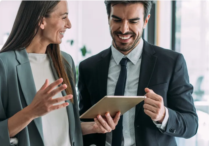 A man and woman holding a tablet