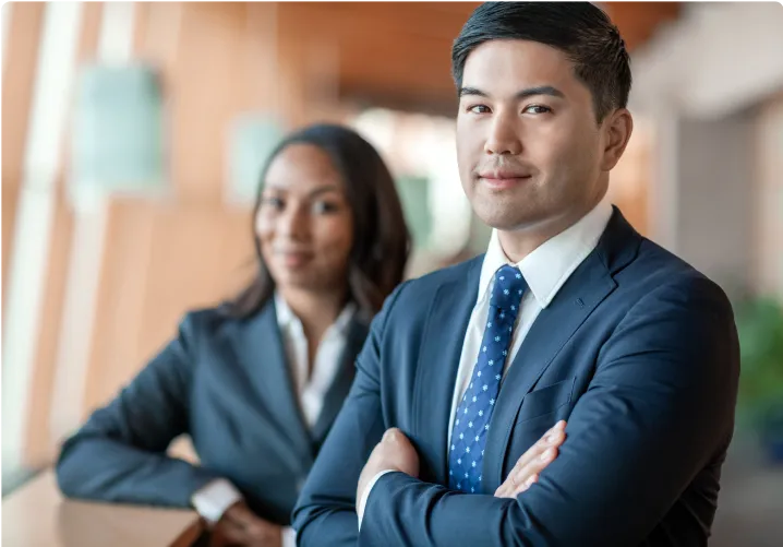 Co-workers in suits standing beside each other in an office