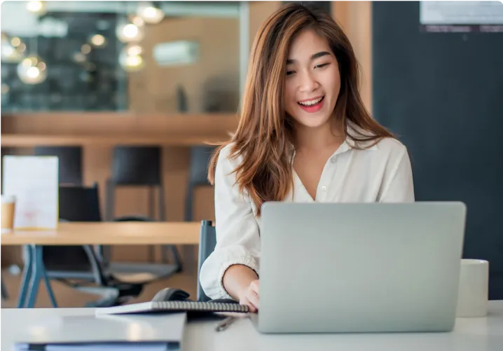 Woman happily working on her laptop