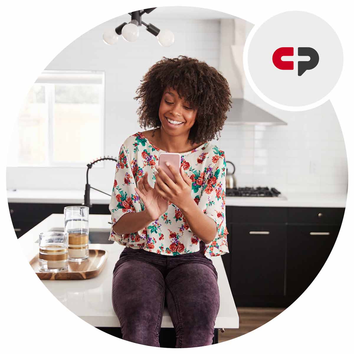 Smiling woman using a phone in a kitchen