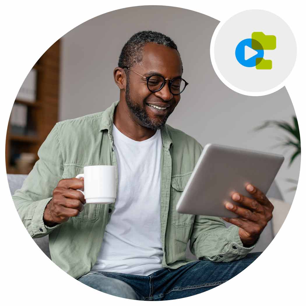 Man holding a tablet and a cup of coffee smiling