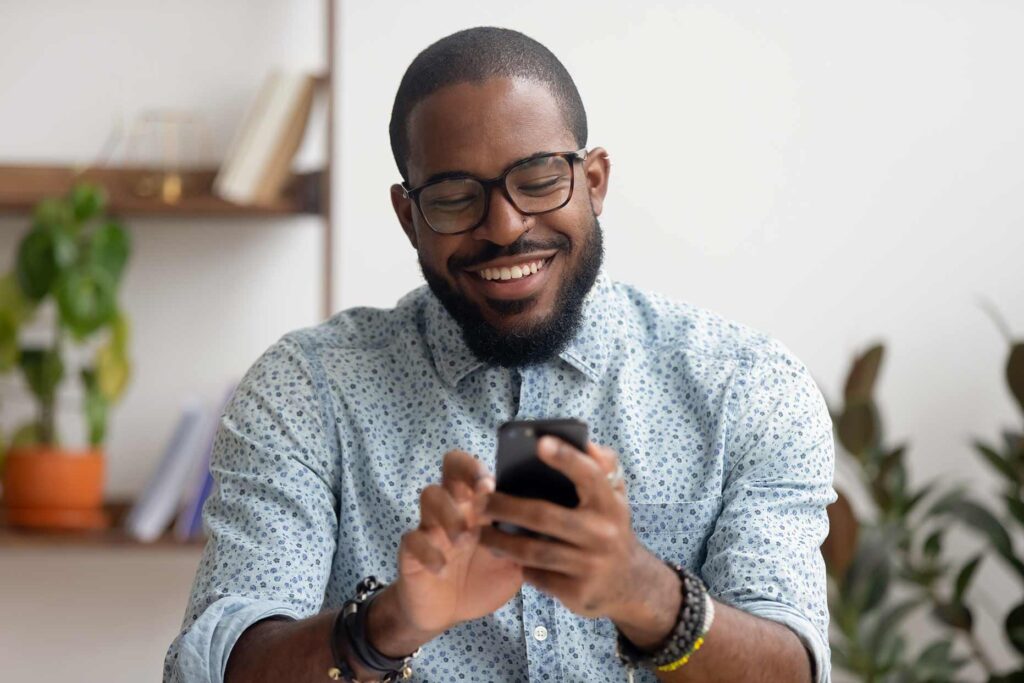 Man sitting at home using his phone