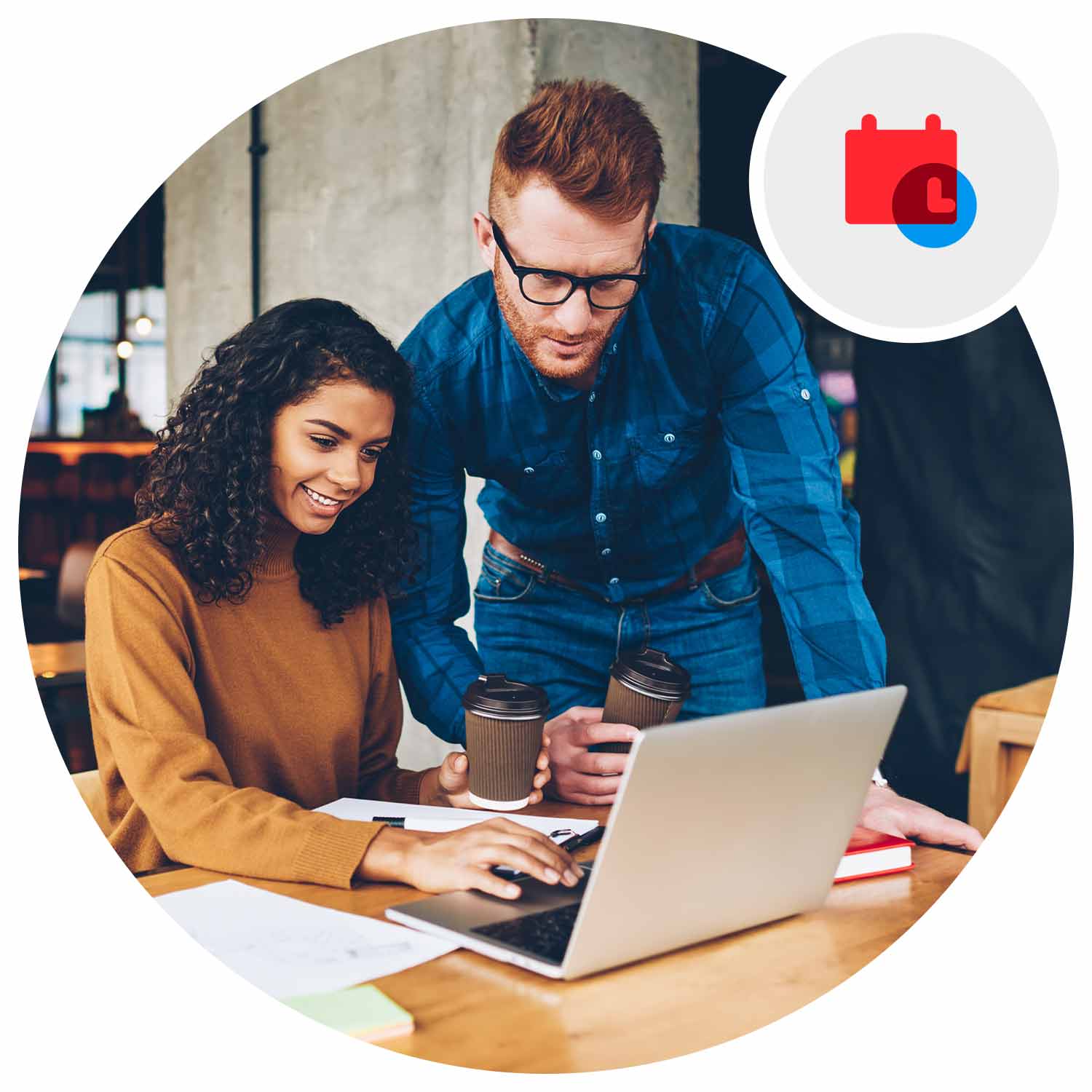 Two people at the office looking at a laptop on a desk