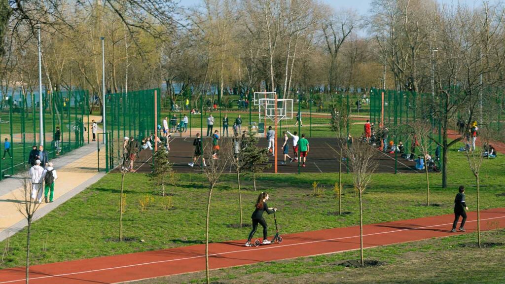 citizens utilizing a municipal park with a basketball court and track