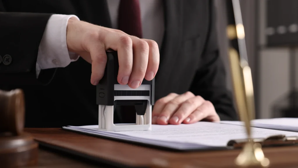 hands stamping an official document