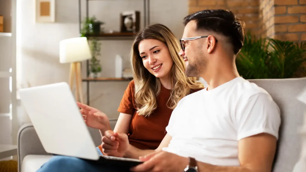 couple on a couch looking at a laptop
