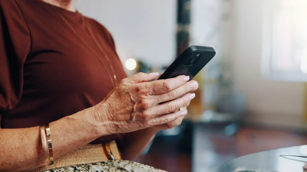 centered on a cell phone in a woman's hands as she types
