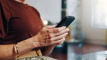 centered on a cell phone in a woman's hands as she types