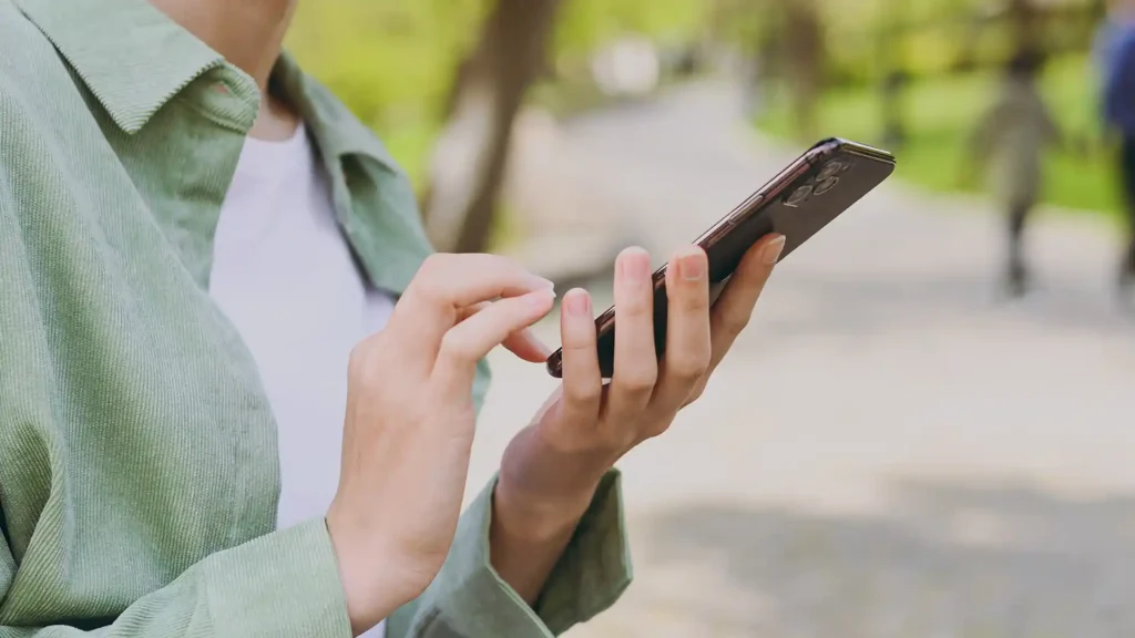 hands using a smart phone in the park