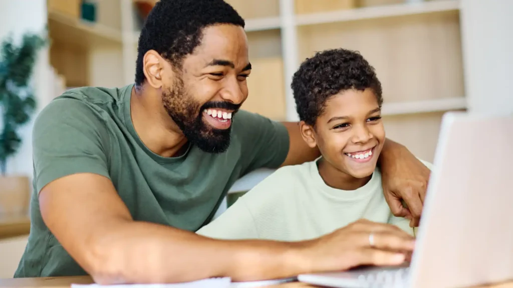 Man and son at table on laptop