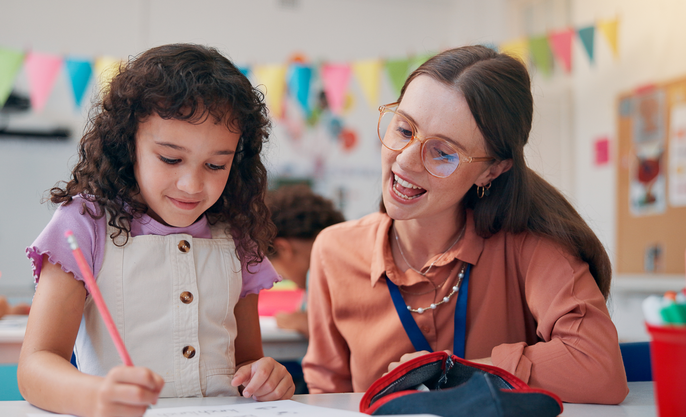 woman and young child sitting at a table looking at a draw pad.