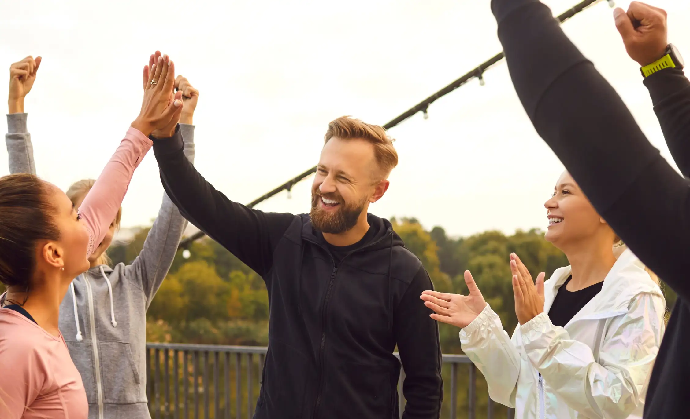 crowd of people cheering, raising their hands in the air.