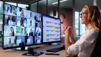 woman working at two screens of a computer