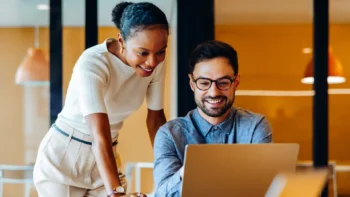 two people looking at a laptop