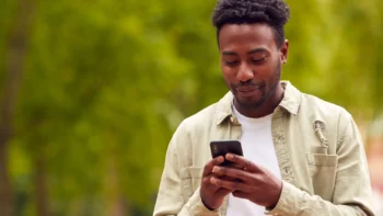 Man outside typing on cell phone