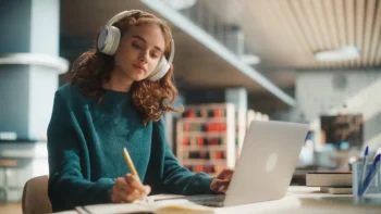 woman with headphones working on laptop