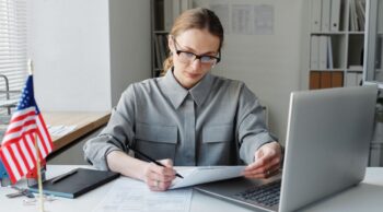 Professional at her computer with a flag on the desk
