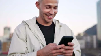 Man in a hoodie looking at cell phone