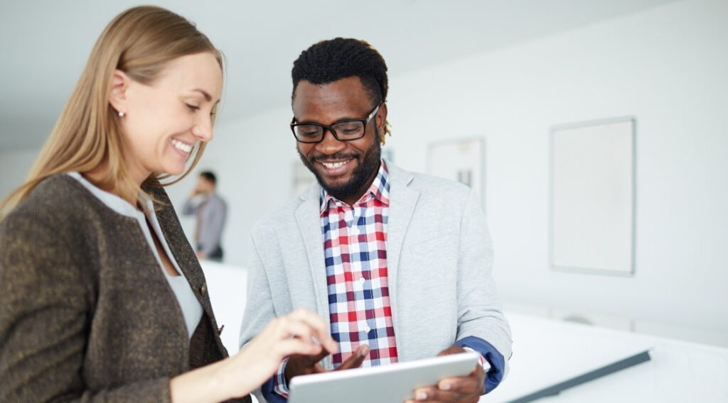 Two office mates looking at a tablet