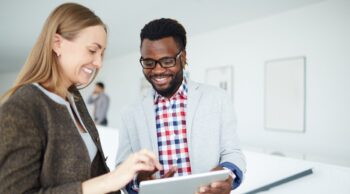 Two office mates looking at a tablet