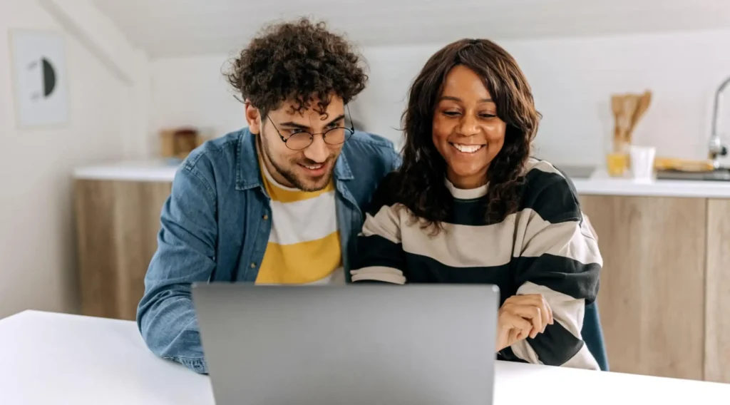 two people looking at a laptop