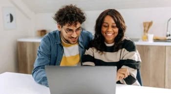 two people looking at a laptop